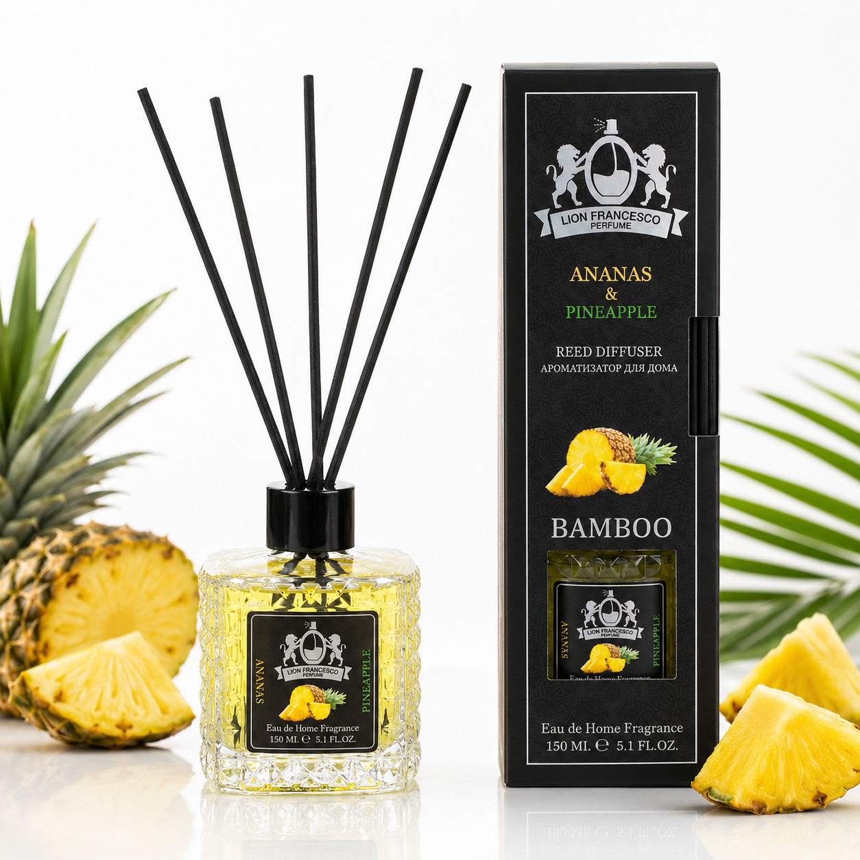A reed diffuser bottle with black reeds and a matching black retail box, both labeled Lion Francisco Republics Ananas & Pineapple Bamboo, styled with pineapple slices and leaves on a white background.