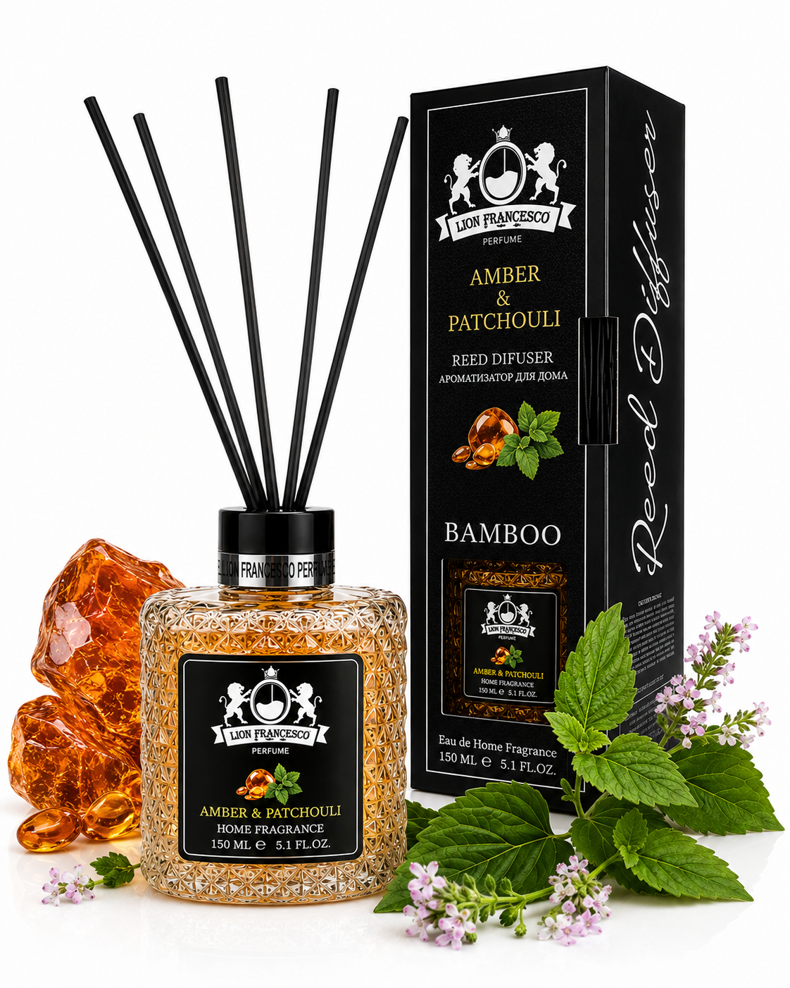 A reed diffuser bottle with black reeds and a black label, shown next to its branded box. The bottle contains amber-toned fragrance beads and is styled with amber crystals, mint leaves, and small pink flowers on a white background.