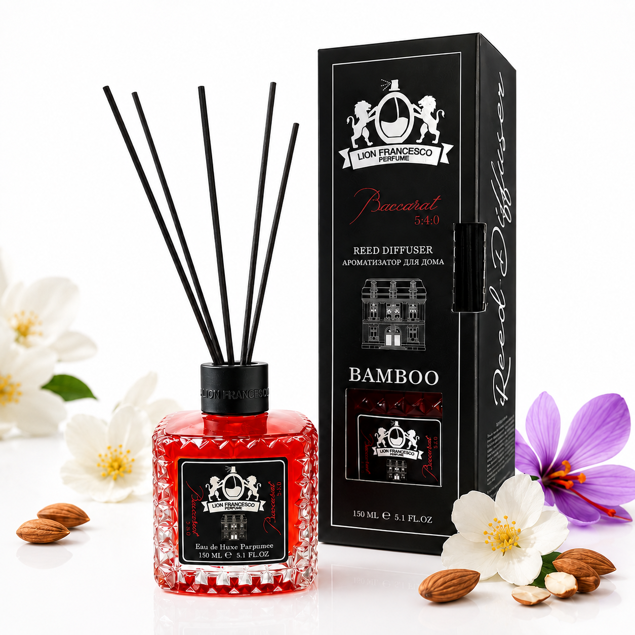 Lion Francesco Baccarat 5:4:0 reed diffuser 150 ml in a red faceted glass bottle with black reeds, displayed beside its black box on a white background with white and purple flowers and almonds.