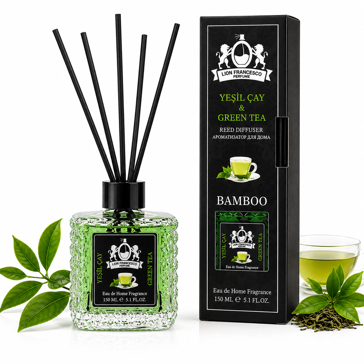 A reed diffuser bottle with black reeds and a green-tinted fragrance liquid, shown beside its black branded box. The scene includes green tea leaves and a glass of tea on a clean white background.