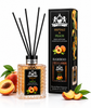 A reed diffuser bottle with black reeds and a matching black retail box, both labeled Lion Francisco Seftali & Peach, shown on a white background with peach slices and leaves as props.